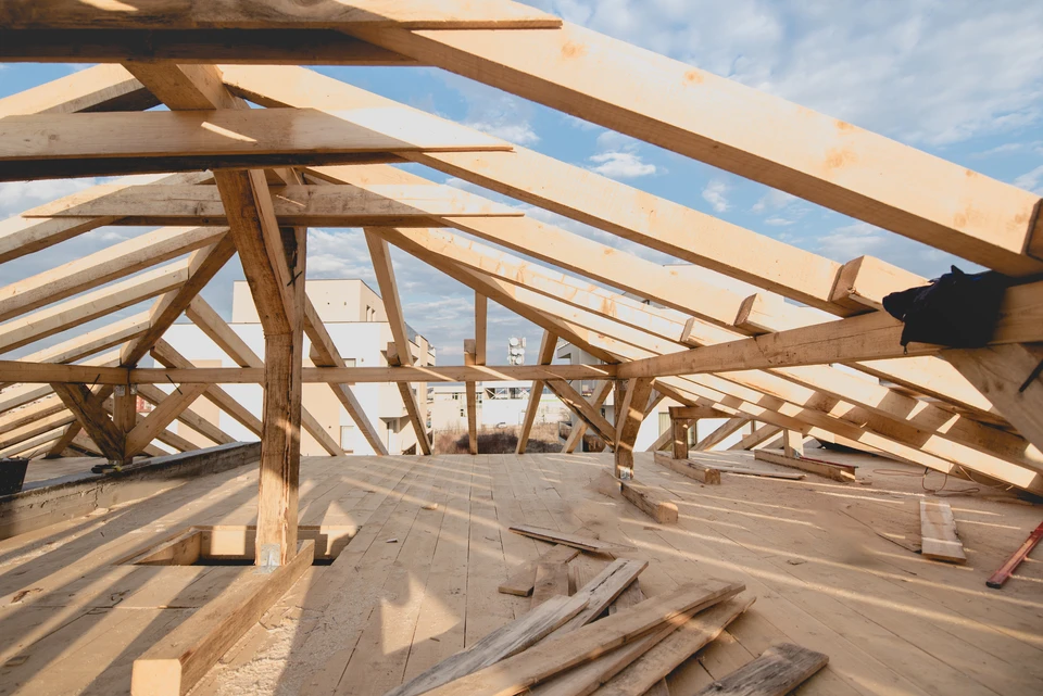 Intérieur d'une maison en bois avec mezzanine, plafond cathédrale et poutres apparentes